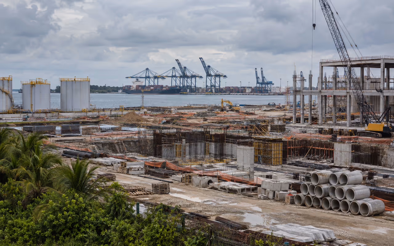 Obra industrial junto a zona portuaria del Golfo con cielo nublado.